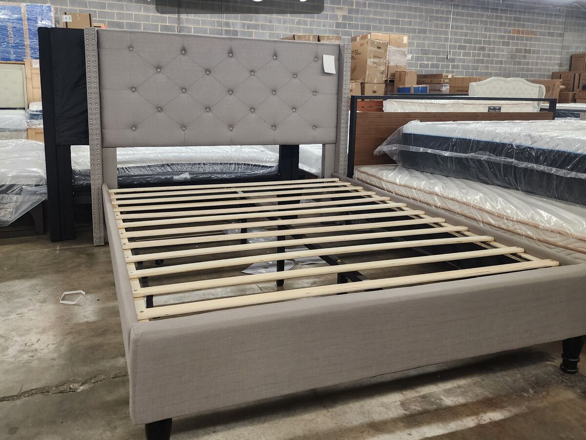 An upholstered platform bed frame in cream.