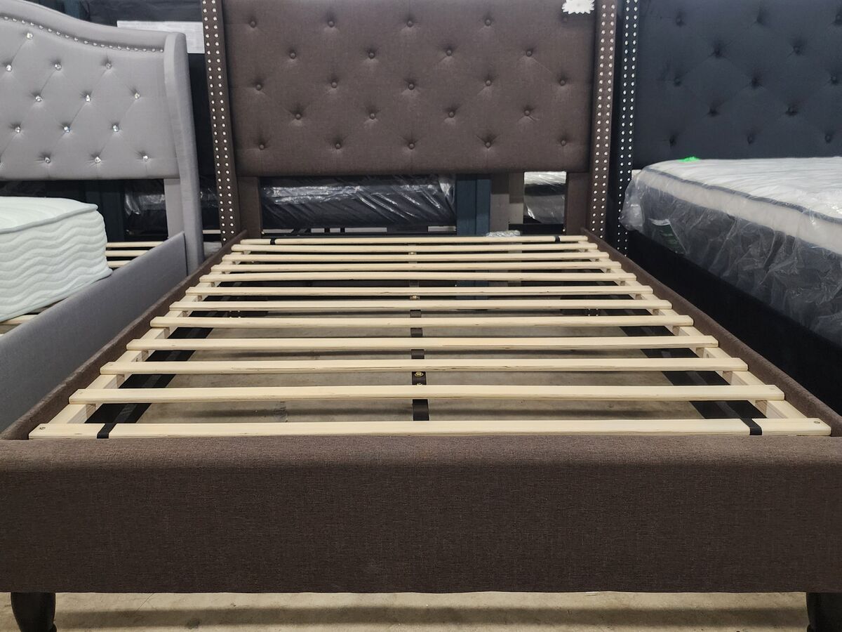 An upholstered platform bed frame in brown.