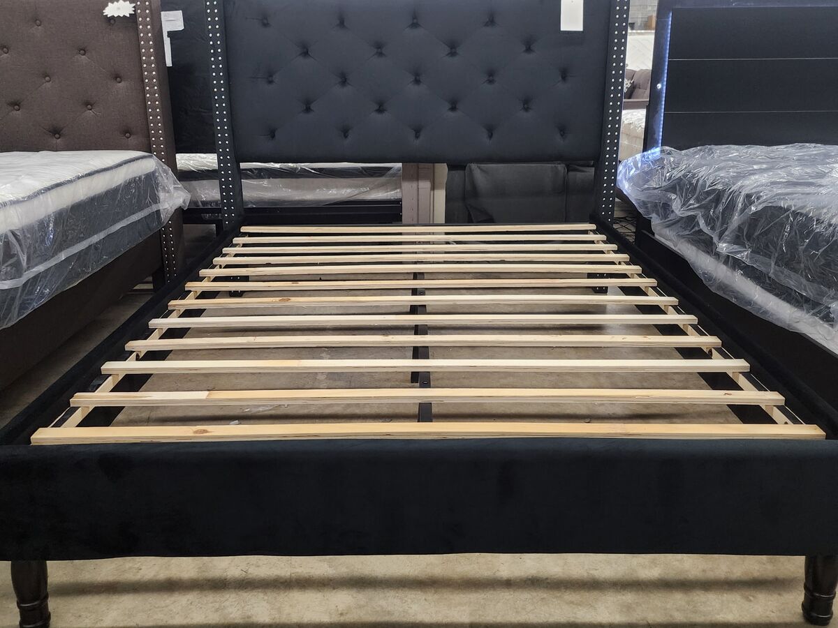 An upholstered platform bed frame in black velvet.